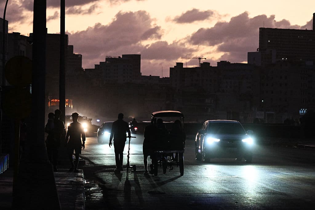 <em>Personas transitan por una calle sin luz durante un apagón nacional en La Habana el 21 de marzo de 2026. Un apagón afectó a toda la isla de Cuba el 21 de marzo de 2026, informó el Ministerio de Energía en el segundo apagón nacional en menos de una semana. (Foto de Yamil LAGE / AFP vía Getty Images)</em>