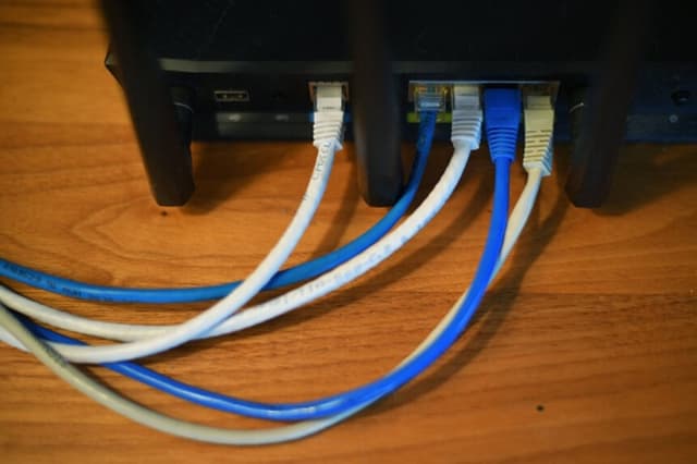 Se ven cables Ethernet saliendo de la parte trasera de un router inalámbrico en Washington D. C. el 21 de marzo de 2019. ( MANDEL NGAN/AFP vía Getty Images).
