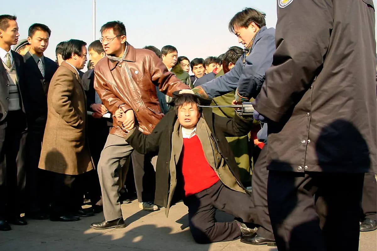 Dos agentes de policía vestidos de civil detienen a un practicante de Falun Gong en la plaza de Tiananmen, en Beijing, el 31 de diciembre de 2000. Minghui