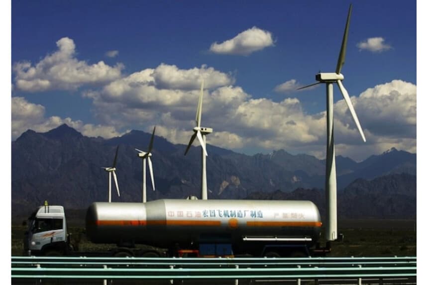 Un camión petrolero pasa junto a turbinas eólicas en la planta de energía eólica de Dafancheng, la más grande de su tipo en Asia, en Dafancheng de la Región Autónoma Uygur de Xinjiang, China, en 2007. (Fotos de China/Getty Images)