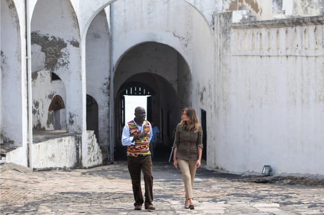 La primera dama Melania Trump (derecha) y Kwesi Essel Blankson, educador del museo, recorren el Castillo de Cape Coast, un antiguo fuerte de tráfico de esclavos, en Cape Coast, Ghana, el 3 de octubre de 2018. ( Saul Loeb/AFP/Getty Images)
