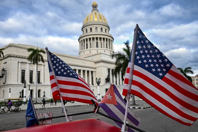 Dos banderas estadounidenses y una cubana ondean en el techo de un triciclo frente al Capitolio en La Habana, el 3 de febrero de 2026. (Foto de YAMIL LAGE / AFP vía Getty Images)