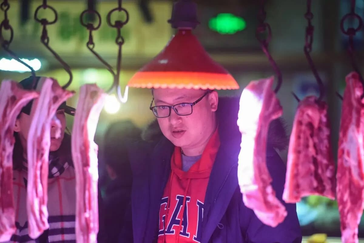 Un cliente observa la carne de cerdo a la venta en un mercado de la ciudad de Hangzhou, en la provincia oriental china de Zhejiang, el 9 de enero de 2020. (AFP vía Getty Images)