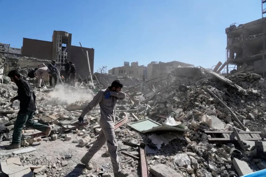 Un grupo de hombres inspecciona las ruinas de una comisaría de policía alcanzada por un ataque aéreo en Teherán, Irán, el 3 de marzo de 2026. (Vahid Salemi/AP)