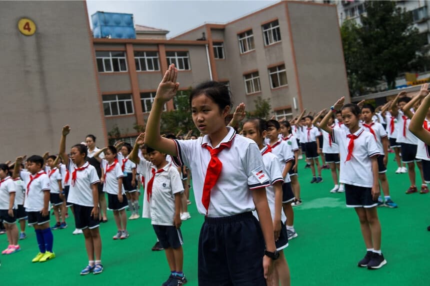 Los estudiantes cantan el himno nacional en el patio de recreo durante la ceremonia de izamiento de la bandera en su escuela en Shanghai el 27 de septiembre de 2017. (Chandan Khanna/AFP vía Getty Images)