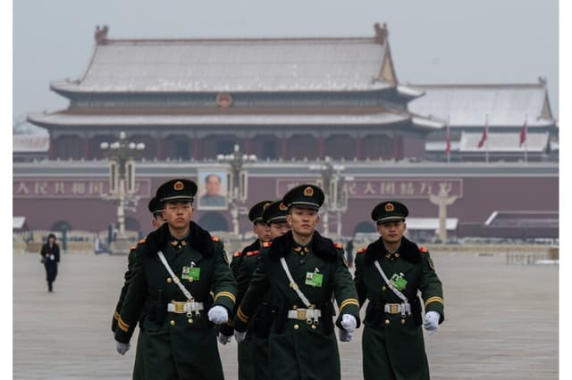 Miembros de la Policía Armada Popular marchan frente a un retrato del exlíder chino Mao Zedong en la Plaza de Tiananmen en Beijing el 5 de marzo de 2026. (Kevin Frayer/Getty Images)