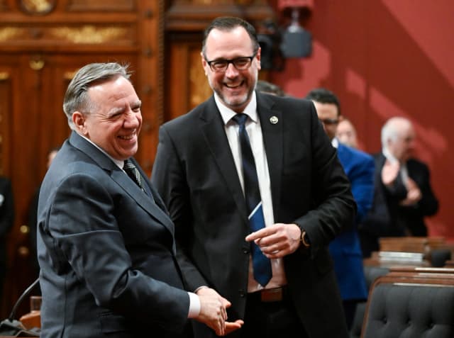 El primer ministro de Quebec, François Legault (izquierda), felicita al ministro de Inmigración, Francización e Integración de Quebec, Jean-François Roberge, tras la votación de un proyecto de ley sobre laicismo en la Asamblea Nacional, en la sede legislativa de la ciudad de Quebec, el 2 de abril de 2026. (The Canadian Press/Jacques Boissinot).