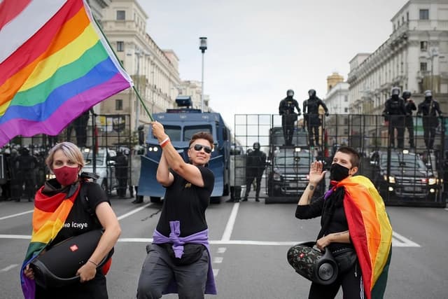 Activistas LGBT se manifiestan con banderas arcoíris y una antigua bandera nacional bielorrusa frente a una barricada policial que bloquea una calle durante una manifestación de la oposición para protestar contra los resultados oficiales de las elecciones presidenciales en Minsk, Bielorrusia, el 6 de septiembre de 2020. (Foto de archivo de AP)
