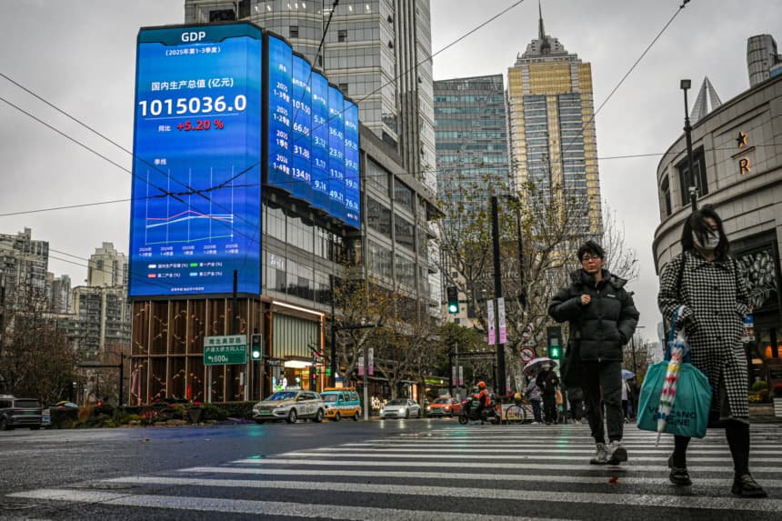 Personas caminan frente a una pantalla que muestra las cifras del producto interno bruto en una calle de Shanghái el 19 de enero de 2026. (Jade Gao/AFP vía Getty Images)