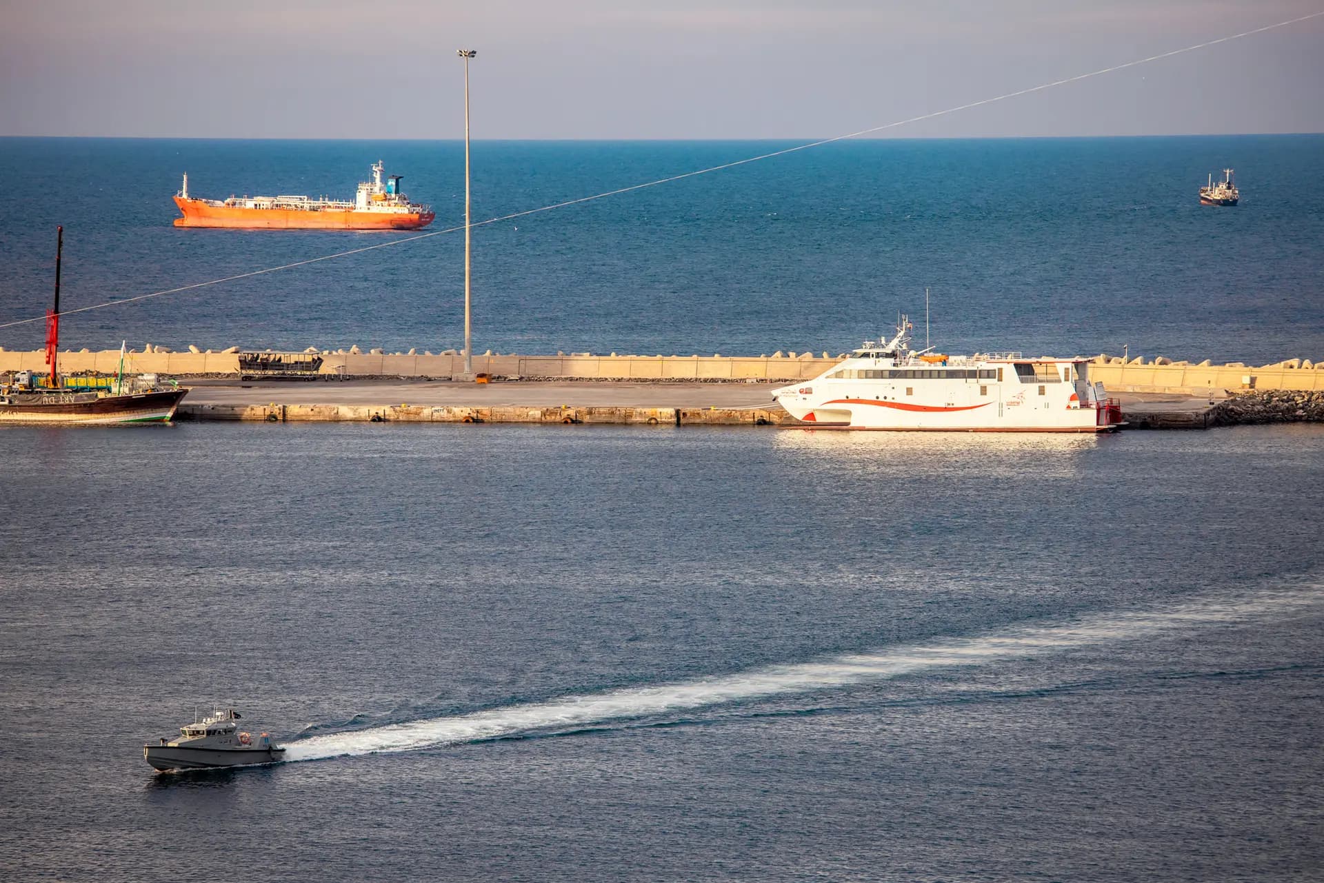 Una lancha rápida de la policía patrulla el puerto mientras petroleros y embarcaciones de alta velocidad permanecen anclados cerca del estrecho de Ormuz en Mascate, Omán, el 30 de marzo de 2026. Elke Scholiers/Getty Images
