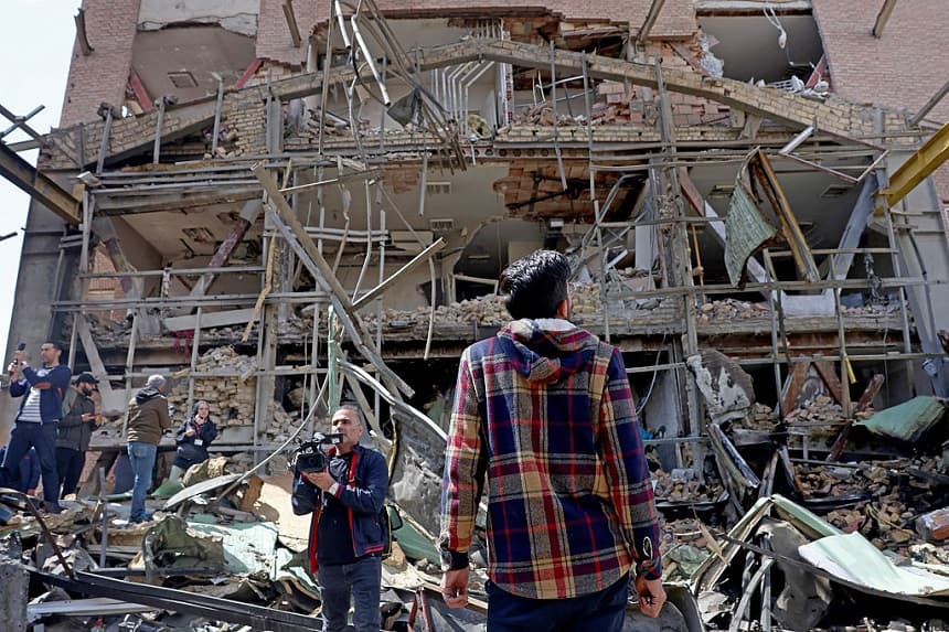 Representantes de los medios de comunicación se reúnen alrededor del edificio dañado de la Universidad Shahid Beheshti tras un ataque, en Teherán, el 4 de abril de 2026. (AFP vía Getty Images) /

