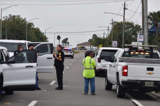 Oficiales del Departamento de Policía de Tampa cortan el tráfico en la autopista South Dale Mabry, cerca de la entrada principal de la base aérea de MacDill —sede del CENTCOM—, tras el aviso de un paquete sospechoso en la puerta de acceso, en Tampa Florida, el 16 de marzo de 2026. (Octavio JONES / AFP vía Getty Images).