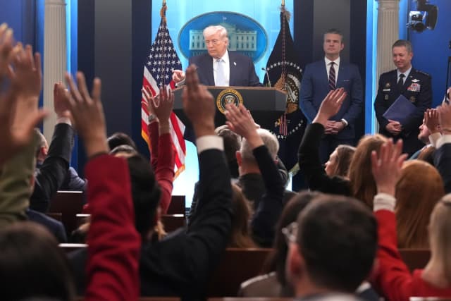El presidente Donald Trump habla con los periodistas durante una rueda de prensa celebrada en la Sala de Prensa James Brady de la Casa Blanca el 6 de abril de 2026, mientras el secretario de Guerra, Pete Hegseth, y el jefe del Estado Mayor Conjunto, el general Dan Caine, escuchan. (Mark Schiefelbein/AP Photo).