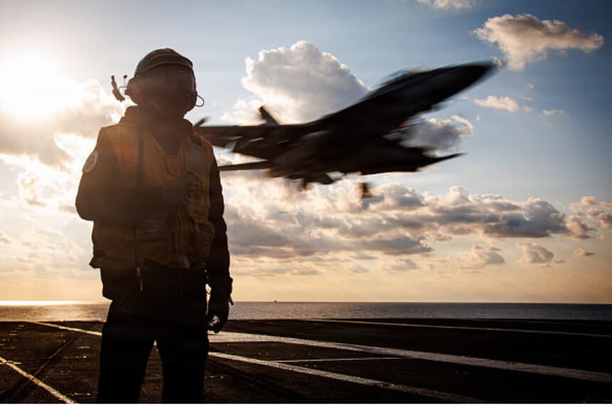 En esta fotografía de archivo facilitada por la Armada de Estados Unidos, un marinero estadounidense desempeña las funciones de oficial de frenado mientras un avión F/A-18F Super Hornet, adscrito al Escuadrón de Cazas de Ataque 213, aterriza en la cubierta de vuelo del portaaviones más grande del mundo, el USS Gerald R. Ford (CVN 78), durante una misión de apoyo a la Operación Epic Fury el 2 de marzo de 2026 en el mar Mediterráneo. (Marina de Estados Unidos a través de Getty Images).