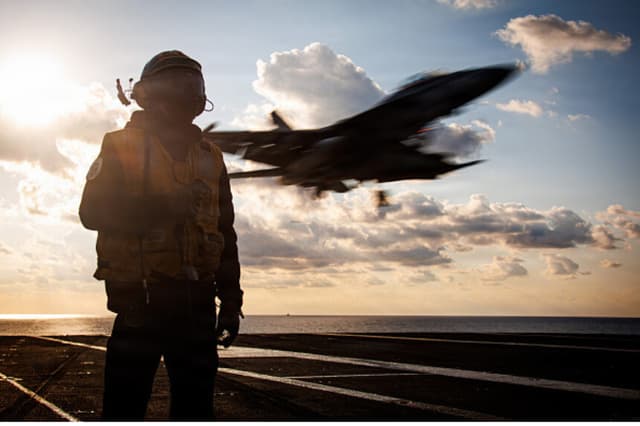 En esta fotografía de archivo facilitada por la Armada de Estados Unidos, un marinero estadounidense desempeña las funciones de oficial de frenado mientras un avión F/A-18F Super Hornet, adscrito al Escuadrón de Cazas de Ataque 213, aterriza en la cubierta de vuelo del portaaviones más grande del mundo, el USS Gerald R. Ford (CVN 78), durante una misión de apoyo a la Operación Epic Fury el 2 de marzo de 2026 en el mar Mediterráneo. (Marina de Estados Unidos a través de Getty Images).