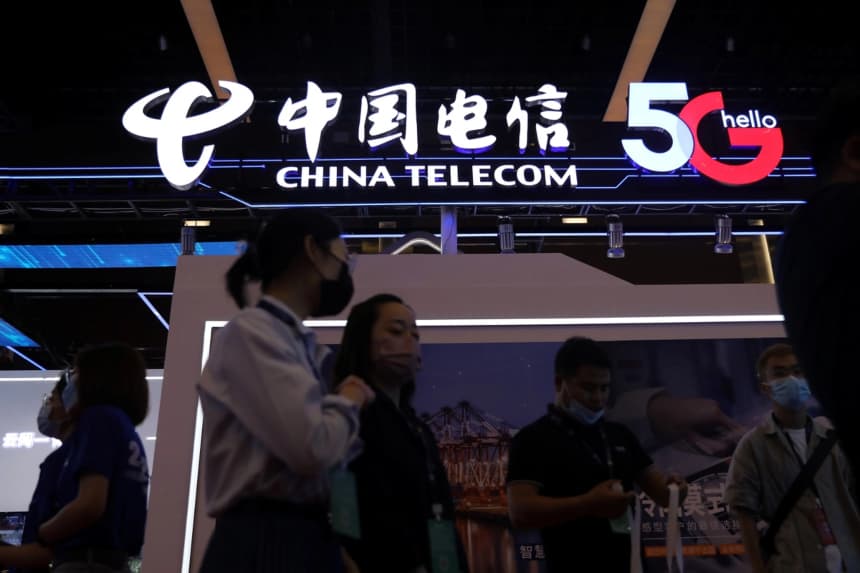 Personas en un stand de China Telecom en una exposición durante la Conferencia de Internet de China, en Beijing, el 13 de julio de 2021. (Tingshu Wang/Reuters)