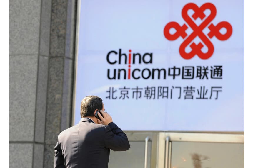 Un empleado de oficina habla por teléfono frente al logotipo de China Unicom en Beijing el 5 de enero de 2012. (Liu Jin/AFP vía Getty Images)