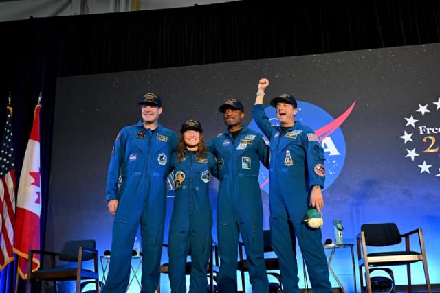 La tripulación de la misión Artemis II de la NASA, compuesta por los astronautas Reid Wiseman, comandante (Dcha.); Victor Glover, piloto (segundo por la derecha); Christina Koch, especialista de misión (segunda por la izquierda); y el astronauta Jeremy Hansen (Izq.), de la Agencia Espacial Canadiense (CSA), comparte unas breves palabras con amigos, familiares y colegas en el aeropuerto de Ellington, cerca del Centro Espacial Johnson de la NASA en Houston, tras regresar a la Tierra después de un viaje de casi 10 días alrededor de la Luna, el 11 de abril de 2026. (NASA/Helen Arase Vargas)