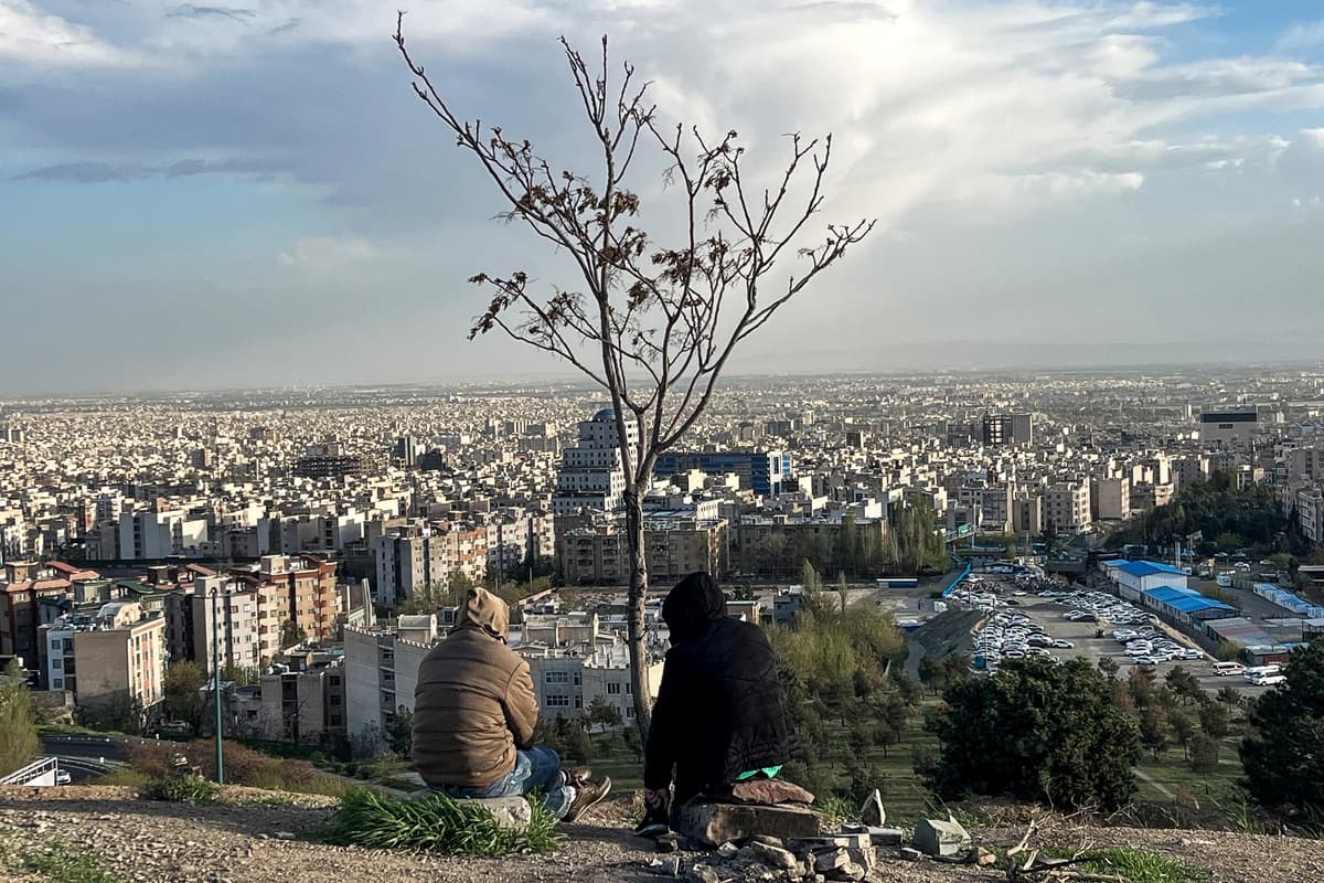 Varias personas contemplan la ciudad desde el parque Pardisan, en Teherán (Irán), el 14 de abril de 2026. (AFP vía Getty Images)
