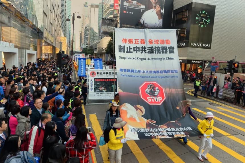 Los practicantes de Falun Gong sostienen una pancarta en la que se lee "Detengan la sustracción forzada de órganos en personas vivas" durante una marcha por el distrito comercial de Tsim Sha Tsui, en la península de Kowloon, en Hong Kong, el 17 de enero de 2015. (Song Pi-lung/The Epoch Times)