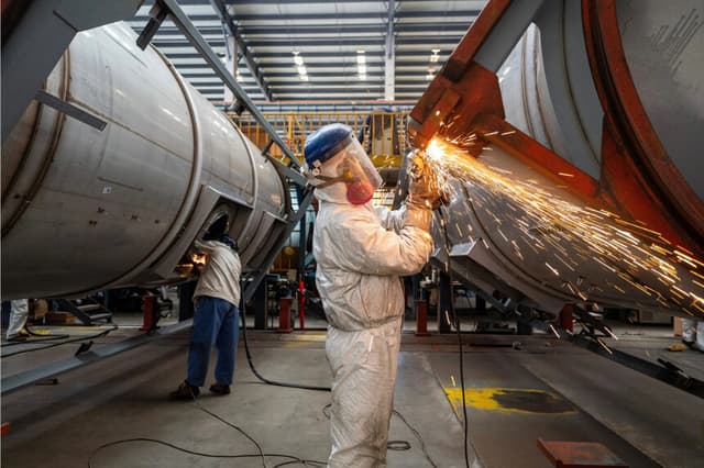 Los trabajadores laboran en una línea de producción, fabricando contenedores cisterna en una fábrica en Nantong, provincia de Jiangsu, China, el 7 de abril de 2025. (cnsphoto vía Reuters)