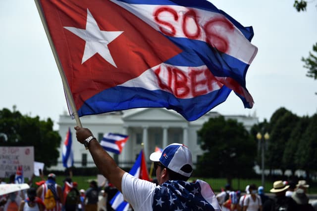 Personas protesta en apoyo a Cuba en la plaza Lafayette, cerca de la Casa Blanca, en Washington D.C., el 26 de julio de 2021, con pancartas y banderas cubanas. Gobiernos latinoamericanos de derecha y otros aliados de Estados Unidos se unieron a Washington para instar a Cuba a respetar los derechos y liberar a las personas detenidas en protestas masivas sin precedentes. (Foto de BRENDAN SMIALOWSKI/AFP vía Getty Images)