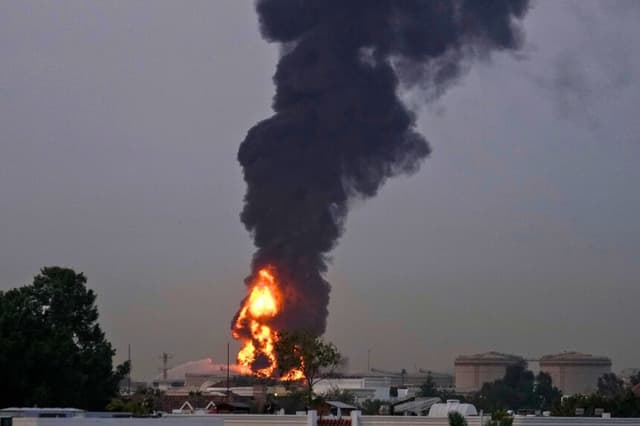 Se observan llamas y columnas de humo tras el impacto de un dron contra un depósito de combustible, lo que obligó a suspender temporalmente los vuelos cerca del Aeropuerto Internacional de Dubái, en los Emiratos Árabes Unidos, el 16 de marzo de 2026. (Foto AP).