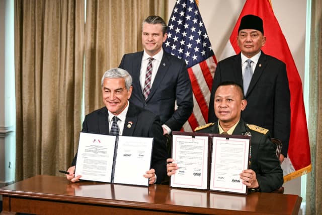 El secretario de Guerra de Estados Unidos, Pete Hegseth (arriba a la izquierda), y el ministro de Defensa de Indonesia, Sjafrie Sjamsoeddin (arriba a la derecha), posan para una foto con la mayor general de la Fuerza Aérea de Estados Unidos, Kelly McKeague (izquierda), y el mayor general de Indonesia, Agus Widodo (derecha), mientras sostienen un memorando de entendimiento firmado en el Pentágono, Washington, el 13 de abril de 2026. (Jim Watson/AFP vía Getty Images)