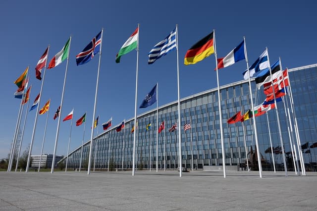 Las 32 banderas de los Estados miembros de la OTAN se ven en el edificio de la sede de la OTAN el 4 de abril de 2025 en Bruselas, Bélgica. (Omar Havana/Getty Images)