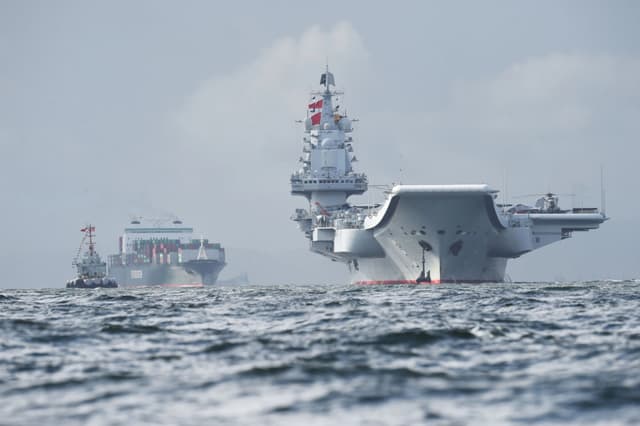 El portaaviones chino Liaoning (derecha) llega a aguas de Hong Kong, el 7 de julio de 2017. (Anthony Wallace/AFP vía Getty Images)