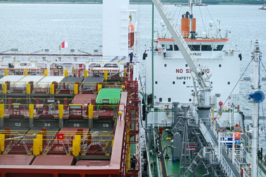 Imagen ilustrativa: Una barcaza de suministro (derecha) abastece con 'metanol verde' —proveniente de fuentes de bajo carbono— a un buque portacontenedores (izquierda) en la terminal del puerto PSA Tuas, en Singapur, el 27 de mayo de 2024. (ROSLAN RAHMAN/AFP via Getty Images)