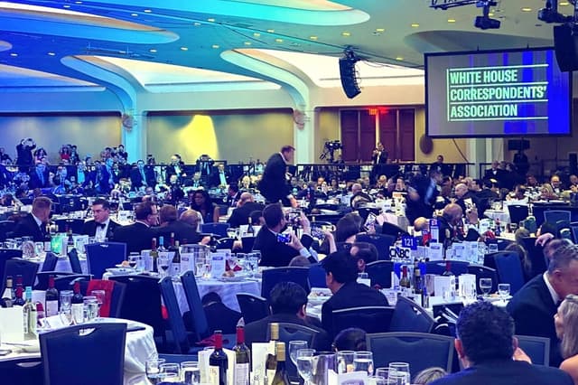 Los invitados comienzan a refugiarse debajo de las mesas tras un tiroteo ocurrido fuera del salón de baile durante la Cena de los Corresponsales de la Casa Blanca, celebrada en el Washington Hilton el 25 de abril de 2026. (AP/Alex Brandon)
