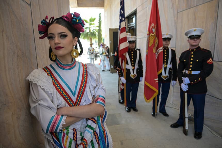 Una bailarina mexicana posa junto a marines estadounidenses durante la ceremonia de inauguración del nuevo edificio de la Embajada de Estados Unidos en Ciudad de México, el 17 de diciembre de 2024. Según el embajador Salazar, el edificio de la Embajada de EE. UU. en México es el más grande de todas las embajadas estadounidenses del mundo, y su construcción ha tenido un costo de mil millones de dólares. (YURI CORTEZ/AFP vía Getty Images).