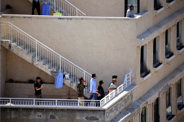 Trabajadores chinos observan cómo un proyectil antimisiles Cúpula de Hierro intercepta un cohete disparado desde Gaza, sobre la ciudad de Ashkelon, Israel, el 4 de mayo de 2019. (Amir Cohen/Reuters)