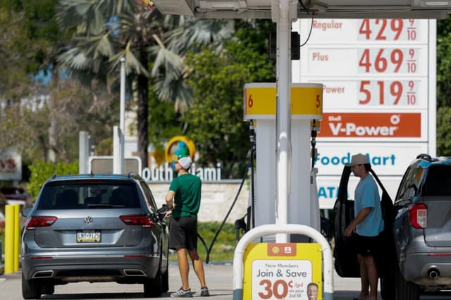Los precios de la gasolina se muestran en un cartel mientras los clientes repostan sus vehículos en una gasolinera de Miami, Florida, el 13 de abril de 2026. (Joe Raedle/Getty Images).