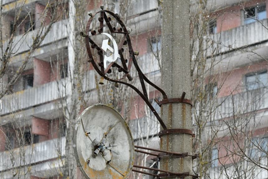 Una fotografía tomada el 8 de diciembre de 2020 muestra símbolos de la era soviética en un poste de la ciudad fantasma de Pripyat, no muy lejos de la central nuclear de Chernóbil. (GENYA SAVILOV/AFP vía Getty Images).