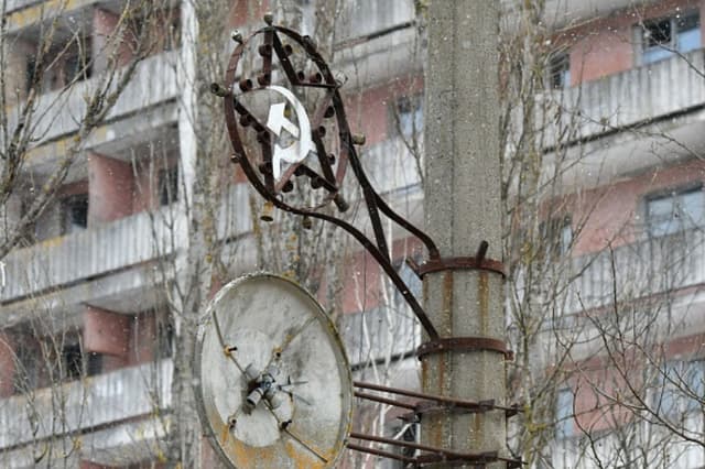 Una fotografía tomada el 8 de diciembre de 2020 muestra símbolos de la era soviética en un poste de la ciudad fantasma de Pripyat, no muy lejos de la central nuclear de Chernóbil. (GENYA SAVILOV/AFP vía Getty Images).