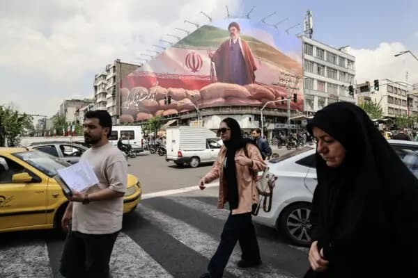 Iraníes pasan junto a una gran valla publicitaria en la que aparece el líder iraní, el ayatolá Mojtaba Jamenei, en una calle de Teherán el 20 de abril de 2026. (Atta Kenare/AFP vía Getty Images)