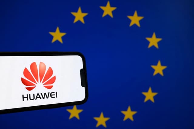 Logotipo del gigante chino de las telecomunicaciones Huawei en un teléfono inteligente frente a una bandera de la Unión Europea, el 13 de marzo de 2025. (Nicolas Tucat/AFP vía Getty Images)