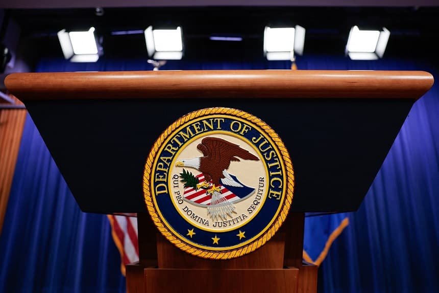 El escudo del Departamento de Justicia de EE. UU. se exhibe en un atril antes de que el fiscal general en funciones, Todd Blanche, ofrezca una rueda de prensa sobre las medidas antifraude del Gobierno de Trump en la sede del Departamento de Justicia en Washington, D. C., el 7 de abril de 2026. ( Kent Nishimura / AFP vía Getty Images)
