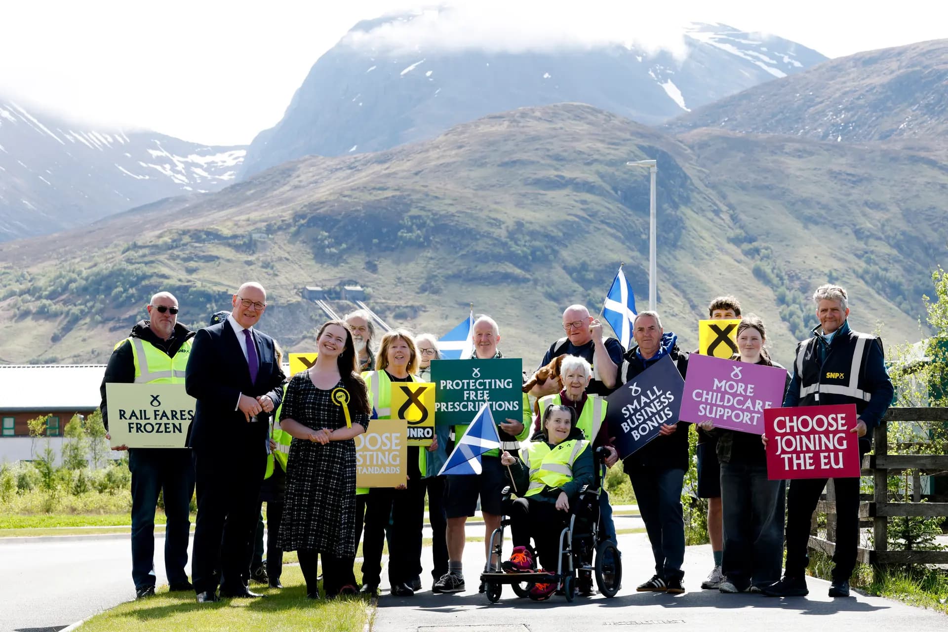 El primer ministro escocés John Swinney, del Partido Nacional Escocés (SNP), hace campaña junto a Eilidh Munro, candidata del SNP por Skye, Lochaber y Badenoch, frente al Ben Nevis en Fort William, Escocia, el 5 de mayo de 2026. Las elecciones parlamentarias de Escocia se celebrarán el 7 de mayo. (Jeff J Mitchell/Getty Images).
