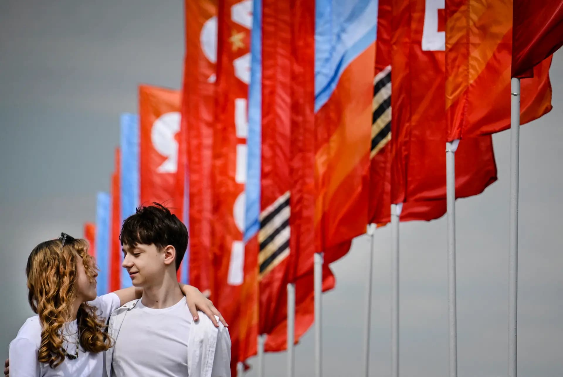 Unos jóvenes pasan junto a una decoración en el centro de Moscú el 5 de mayo de 2026, unos días antes del desfile militar del Día de la Victoria que se celebrará en la Plaza Roja el 9 de mayo. Rusia declaró el 4 de mayo un alto el fuego unilateral con Ucrania desde el 8 hasta el 9 de mayo, fechas en las que Moscú celebra sus conmemoraciones anuales del Día de la Victoria de la Segunda Guerra Mundial, y amenazó con un “ataque masivo con misiles” contra Kiev si Ucrania lo violaba. (Alexander Nemenov/AFP vía Getty Images).