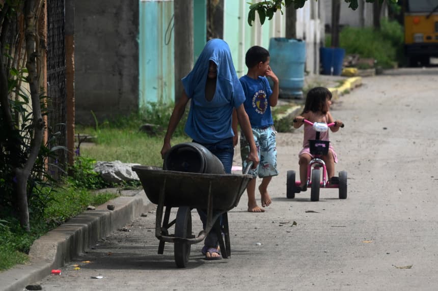 Aquí tienes la traducción:

Niños son vistos en una calle de Chamelecón, en las afueras de San Pedro Sula, Honduras, el 16 de julio de 2022. Chamelecón está bajo el control de pandillas, con una calle que divide los dominios de las bandas Barrio 18 y Mara Salvatrucha (MS-13).(ORLANDO SIERRA/AFP via Getty Images)