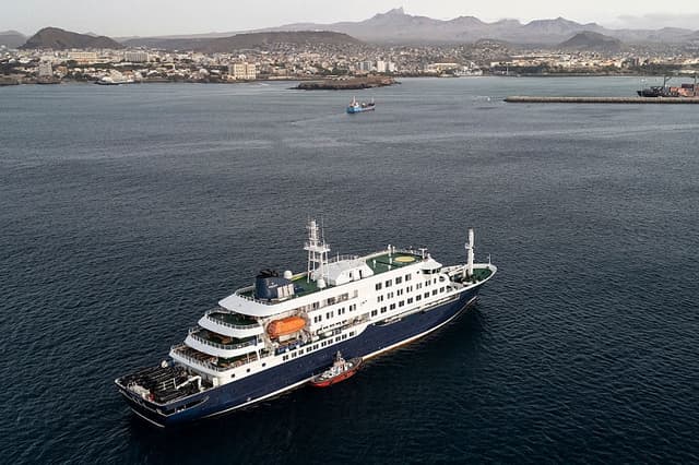 Esta vista aérea muestra al personal sanitario subiendo a bordo del crucero MV Hondius, mientras se encuentra fondeado frente al puerto de Praia, la capital de Cabo Verde, el 6 de mayo de 2026. (AFP vía Getty Images)