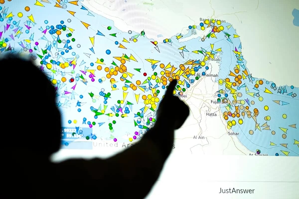 Una ilustración fotográfica muestra a una persona frente a una gran pantalla que muestra los movimientos de los buques en el estrecho de Ormuz en una página web de seguimiento de buques, en Nicosia, el 4 de mayo de 2026. (AFP)