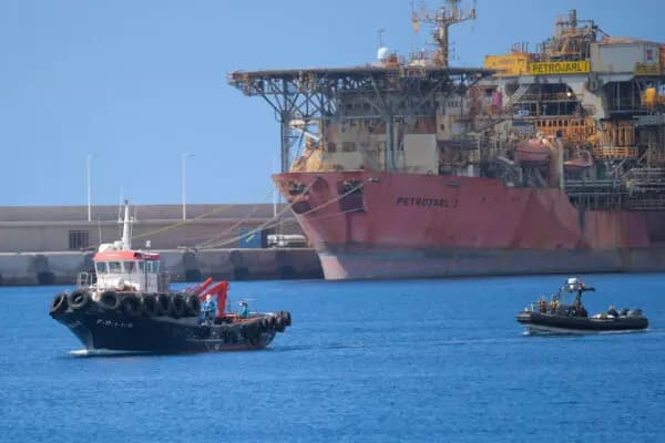 Personas vestidas con trajes protectores azules son evacuadas en un barco del crucero MV Hondius, con bandera holandesa y afectado por hantavirus, en el puerto industrial de Granadilla de Abona en la isla de Tenerife en las Islas Canarias de España el 10 de mayo de 2026. (Jorge Guerrero / AFP vía Getty Images)