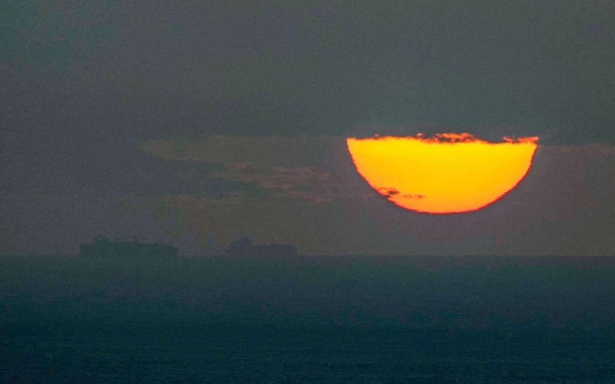 Los barcos navegan por el Golfo Pérsico hacia el Estrecho de Ormuz mientras el sol se pone en los Emiratos Árabes Unidos el 23 de marzo de 2026. (Foto AP)