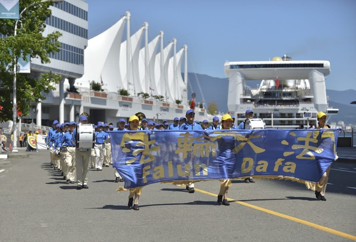 Los seguidores de Falun Dafa en Vancouver participan en un desfile para conmemorar el 19.º aniversario del inicio de la persecución contra Falun Dafa en China, el 14 de julio de 2018. (The Epoch Times).