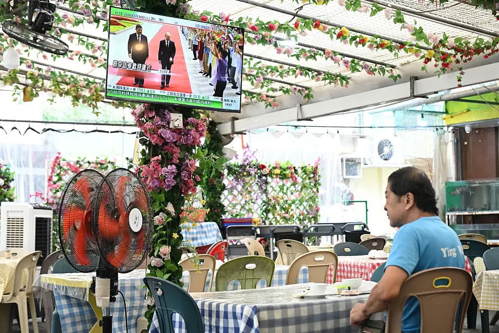 En un restaurante de Hong Kong se ve en la televisión al presidente ruso, Vladímir Putin, junto al líder chino, Xi Jinping, durante una ceremonia de bienvenida celebrada en el Gran Salón del Pueblo de Beijing el 20 de mayo de 2026. Putin afirmó que las relaciones entre ambos países han alcanzado un "nivel sin precedentes" (Peter Parks/AFP vía Getty Images)