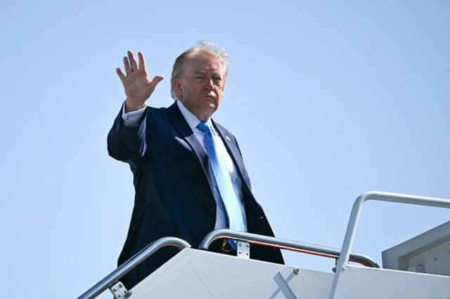 El presidente estadounidense Donald Trump saluda al abordar el Air Force One en la Base Conjunta Andrews, Maryland, el 20 de mayo de 2026, rumbo a New London, Connecticut, para pronunciar el discurso de graduación de la Academia de la Guardia Costera de EE. UU. (Kent Nishimura / AFP vía Getty Images).